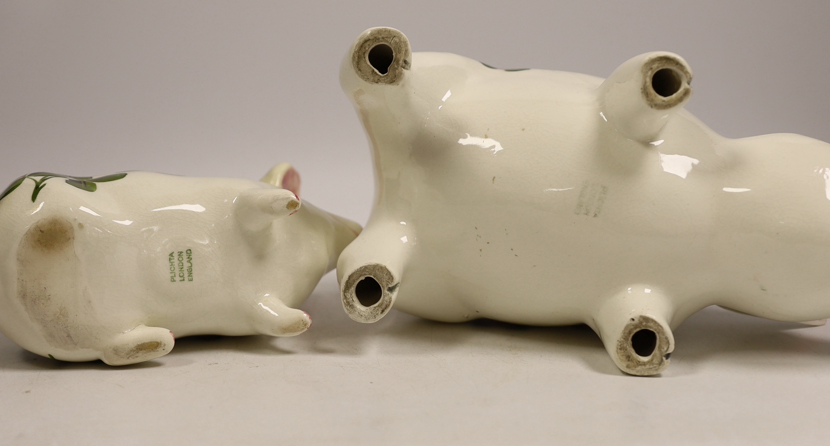 A Plichta rose decorated pig money box, 16cm, and a Plichta rose decorated hatpin holder pig, 23cm and two other Plichta pigs